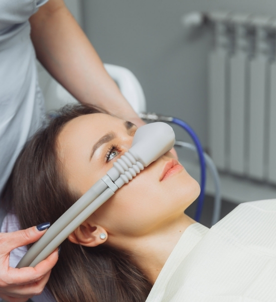 Patient receiving sedation dentistry with a nasal mask in a dental office, emphasizing comfort and anxiety reduction during treatment.
